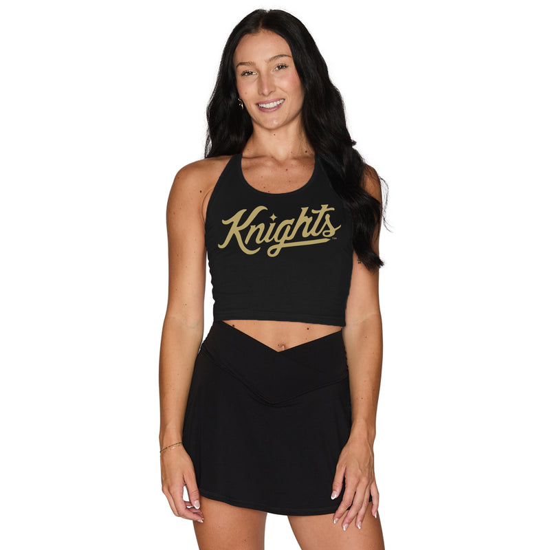 Woman wearing a black crop top with 'Knights' text and black skirt on a white background